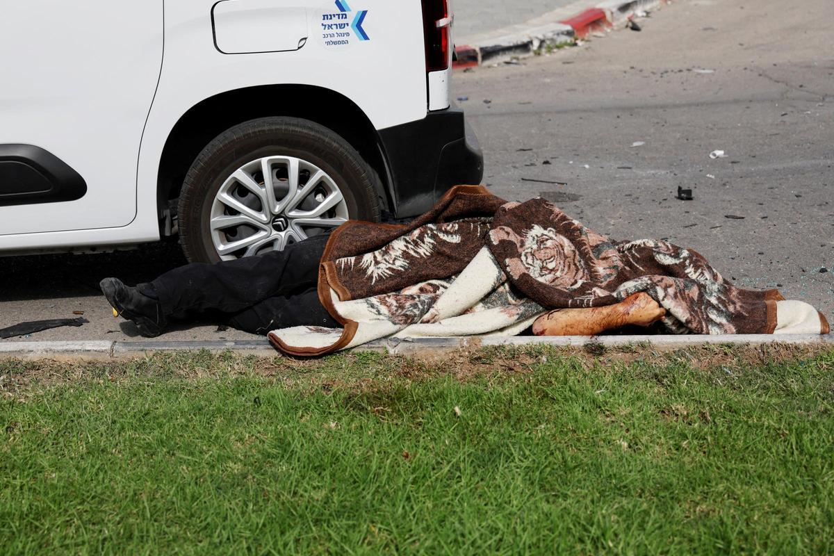 Un cuerpo cubierto por una manta yace en la carretera en Sderot, en Israel, en medio del ataque sorpresa de Hamás desde la Franja de Gaza.