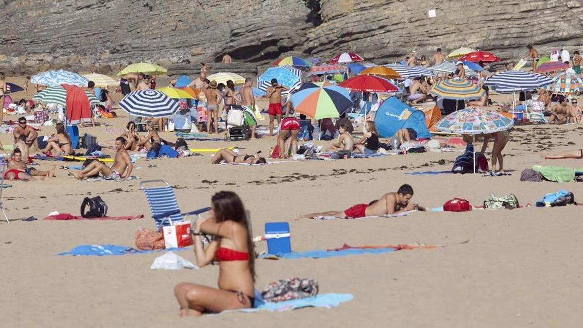 Bañistas en la playa de Rodiles.