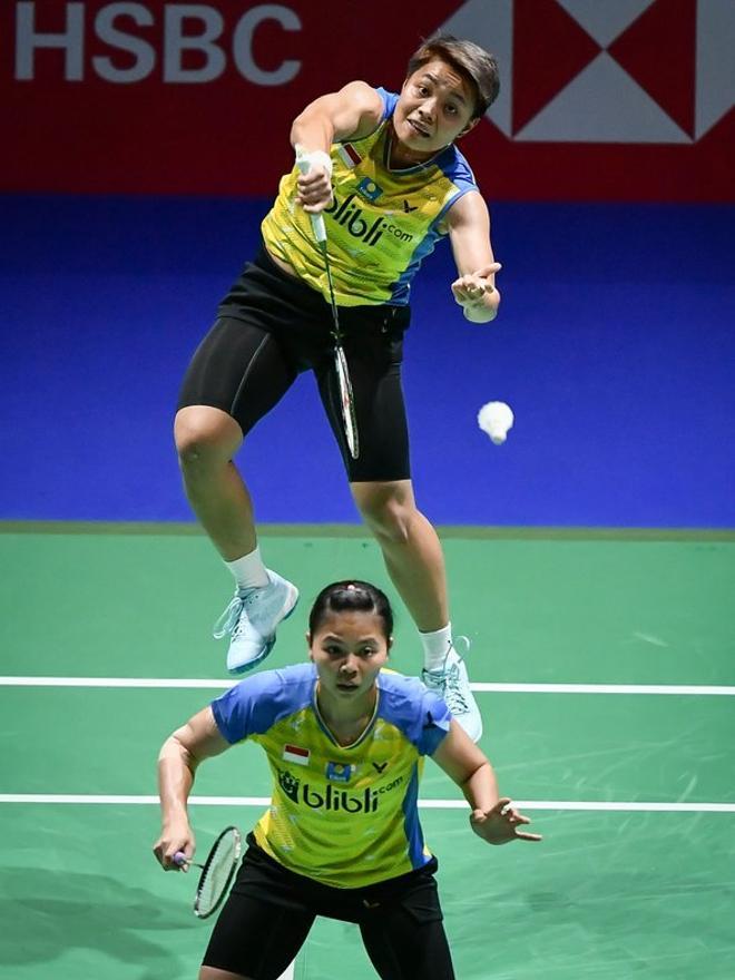 Apriyani Rahayu (arriba) sirve junto a su compañera de equipo Greysia Polii en el volante a Mayu Matsumoto y Wakana Nagahara durante su semifinal de dobles femenino en el BWF Badminton World Championships en el St. Jakobshalle en Basilea.