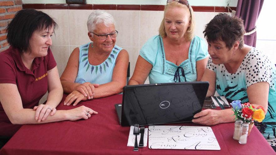 Mujeres británicas residentes en Mollina repasan un periódico en lengua inglesa.