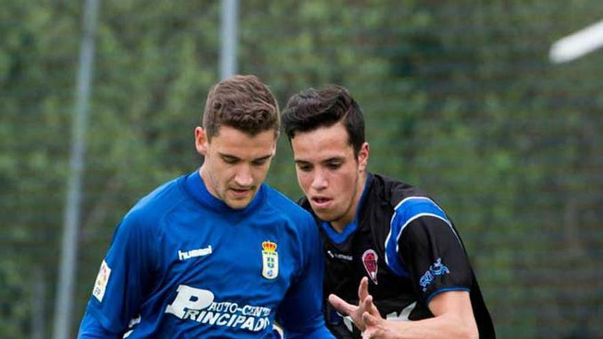 Edo, del Oviedo B, presionado por un rival del Astur.