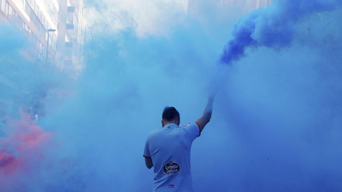 Un aficionados del Celta entre el humo de las bengalas, en la previa del partido contra el Girona