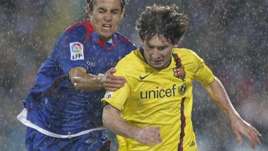 Messi se escapa de Cortés bajo el diluvio que cayó sobre Getafe.