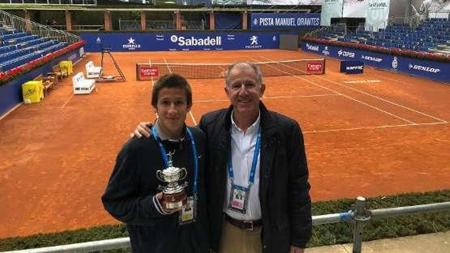 Miguel Avendaño, con el trofeo, junto a su padre, Juan, en la pista central del Trofeo Conde de Godó.