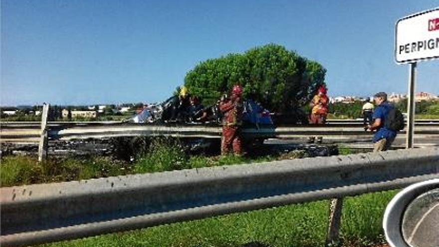 Un equip de bombers treballant en un dels vehicles accidentats.