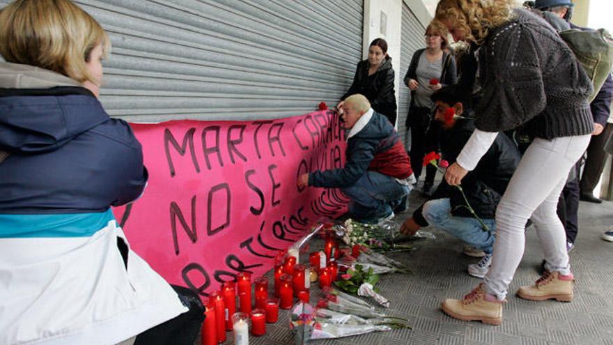 Velas en la puerta del bar donde apareció muerta la mujer. // Efe