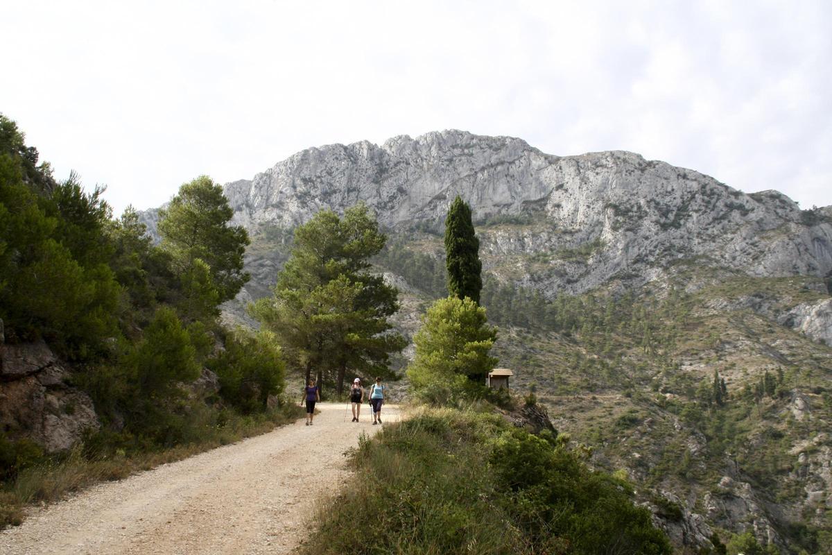 Tres senderistas caminan por el paraje de la Ombria, con el Benicadell al fondo, en una imagen de archivo.