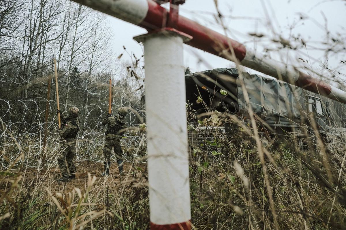 Soldados del ejército polaco arreglan bobinas de alambre de púas en una valla a lo largo de la frontera polaca, con el enclave ruso de Kaliningrado, cerca de Zerdziny, Polonia