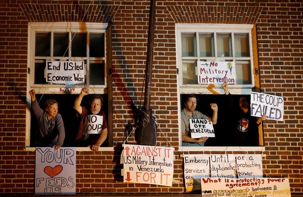 Los partidarios del presidente venezolano Nicolás Maduro en la ventana de la embajada venezolana después de que los agentes federales intentaron desalojar y arrestar a cuatro partidarios de Maduro y poder terminar con su ocupación de varias semanas en Washington.