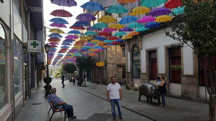 Vilariño posa en la inauguración de la decoración de la calle, donde se colgaron 234 paraguas de colores y tres bancos con idénticos tonos.