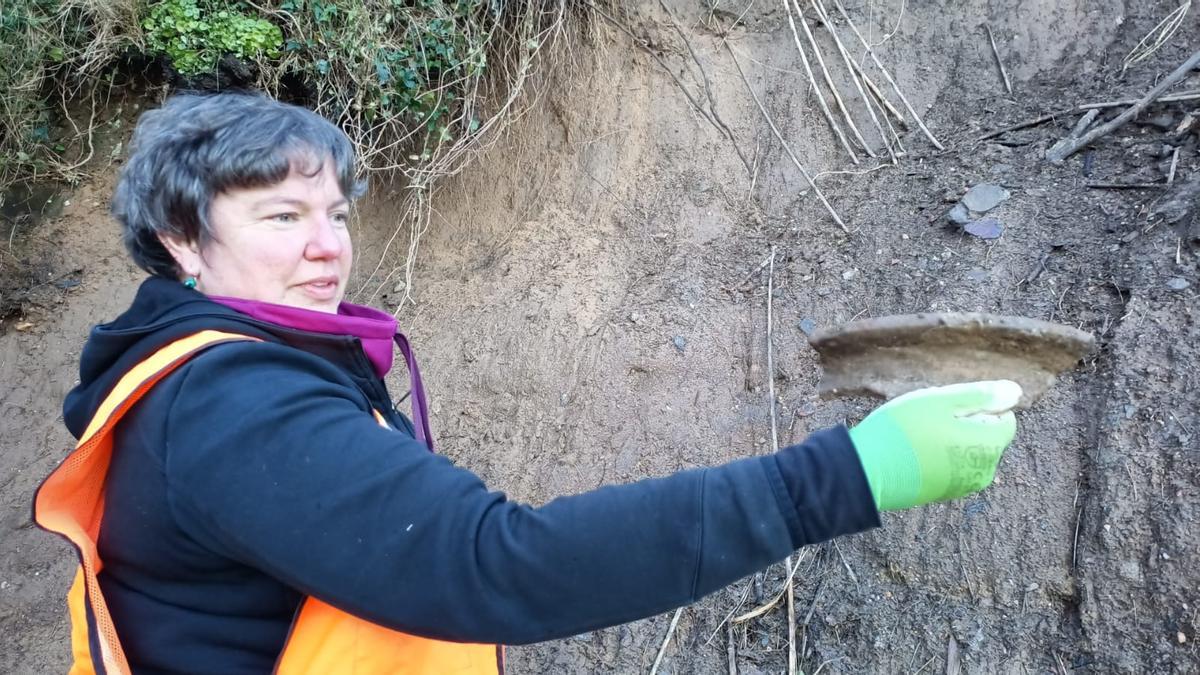 Una de las arqueólogas muestra una pieza cerámica de las que se estudiarán.