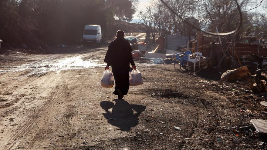 Archivo - Una mujer camina con unas bolsas en la Cañada Real Galiana.