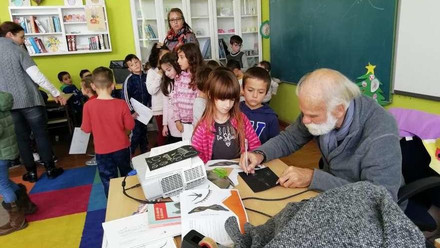 El escritor firma autógrafos a los alumnos.