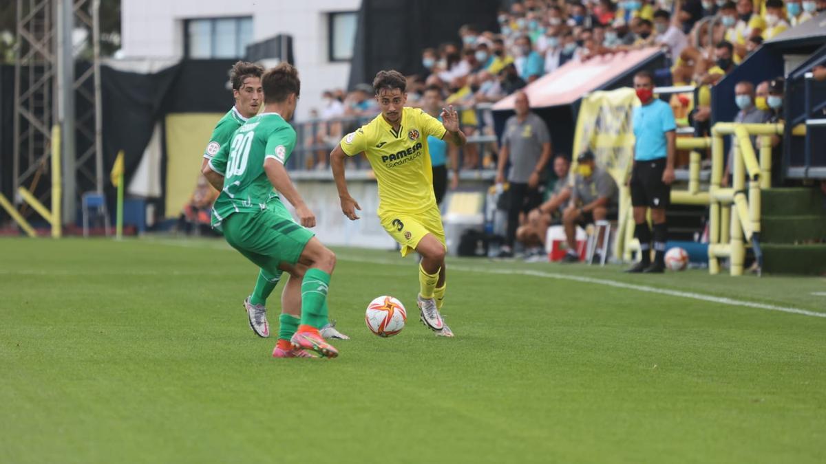 El lateral del Villarreal B Goyo conduce ante la presión de dos jugadores del Cornellá.