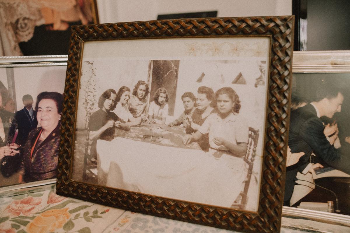 Algunas de las fotos personales que Ángeles Espinar tiene en su taller de mantones de Manila. En la imagen central, Espinar posa junto a un grupo de bordadoras en el taller de su madre, durante su juventud.