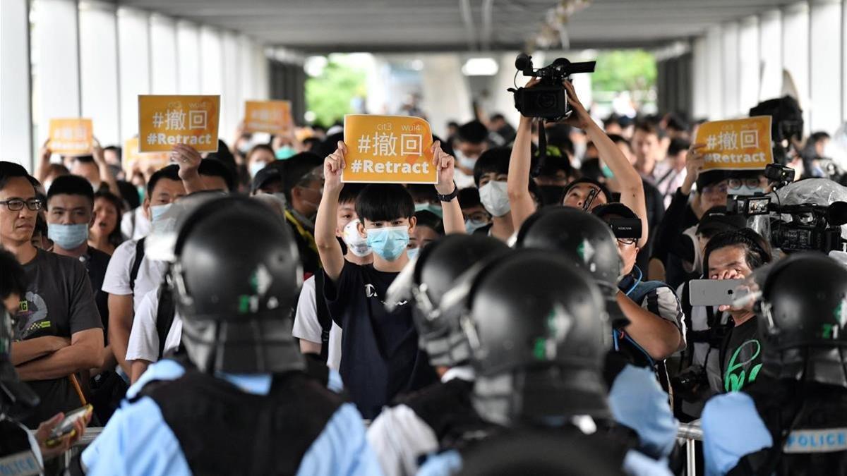 Un grupo de manifestantes sostienen pancartas de protesta contra la policía hongkonesa, este jueves.