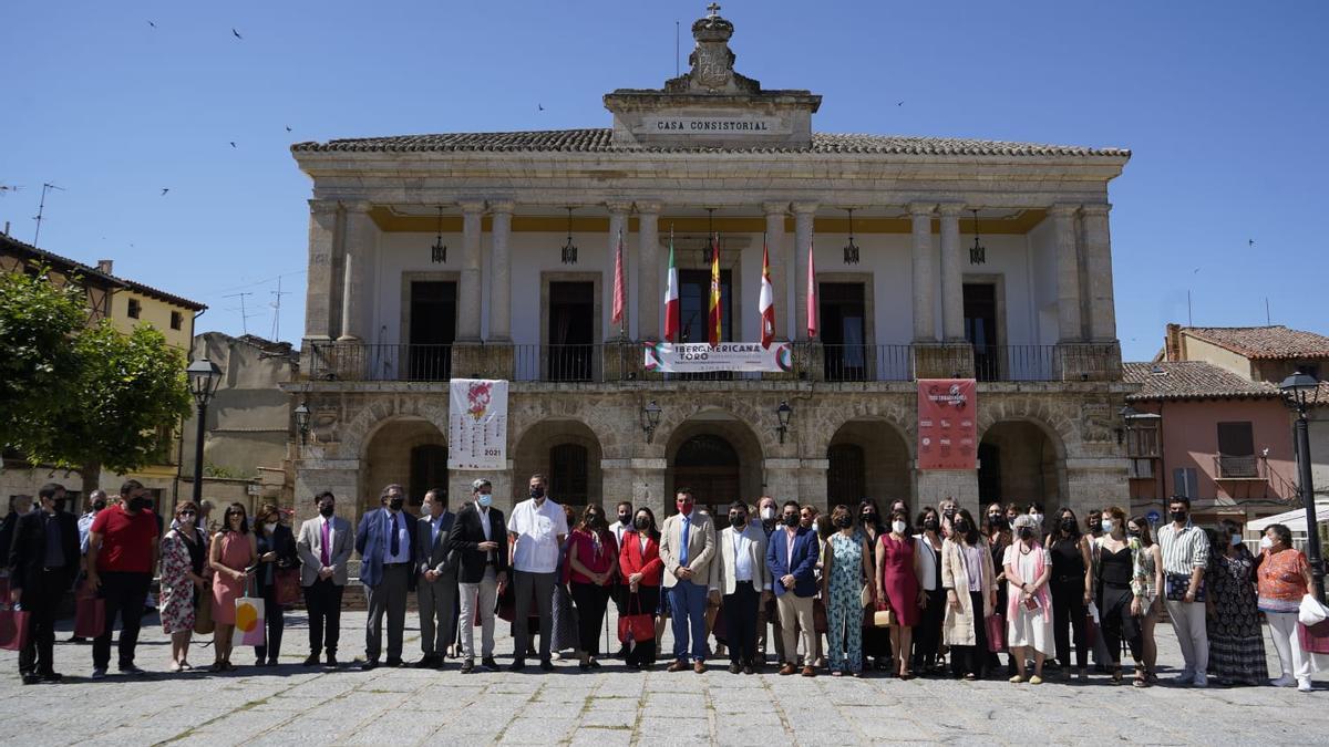 Autoridades, artistas e invitados al acto de inauguración de La Iberoamericana posan junto al Ayuntamiento