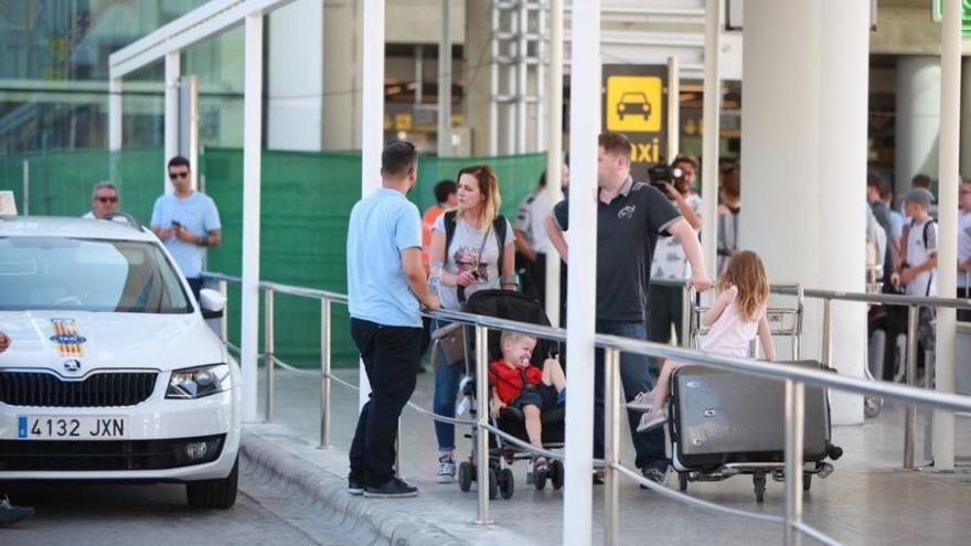 Neben der Rolltreppe warten die Passagiere auf die Taxis.