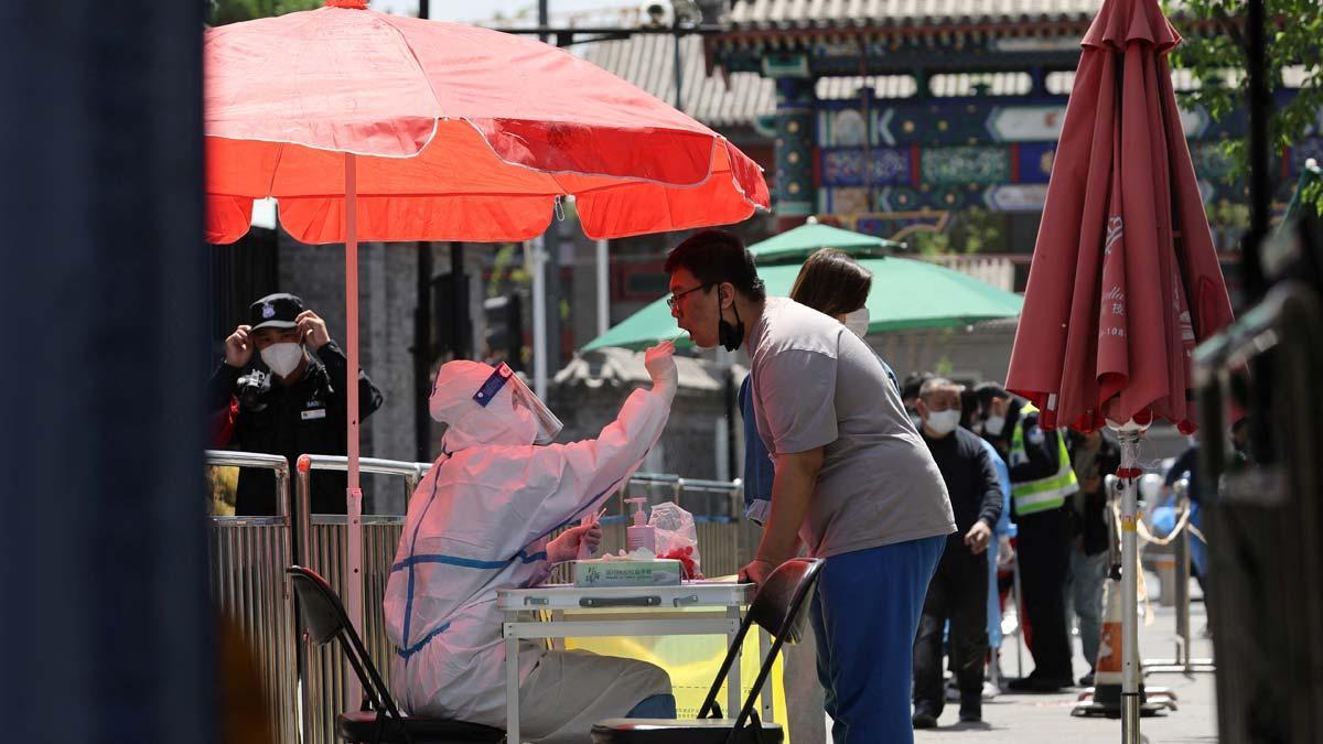 Un sanitario toma una muestra de una prueba de coronavirus en una carpa instalada en Pekín