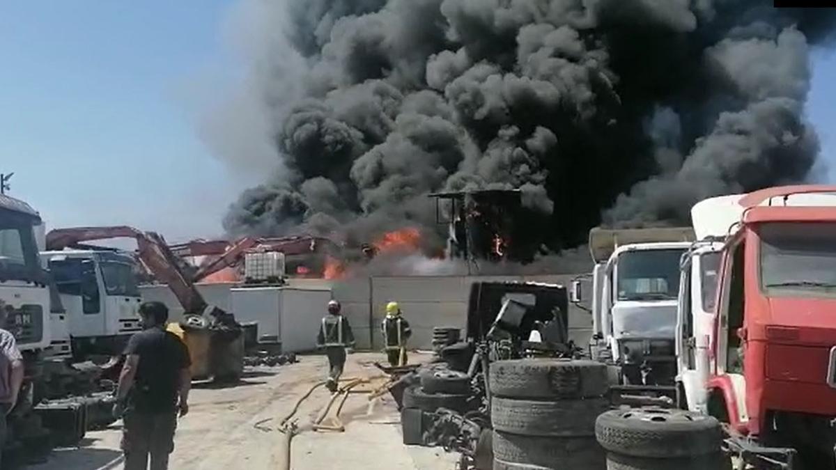 Los bomberos tratan de extinguir un incendio registrado en un desguace de Los Asperones.