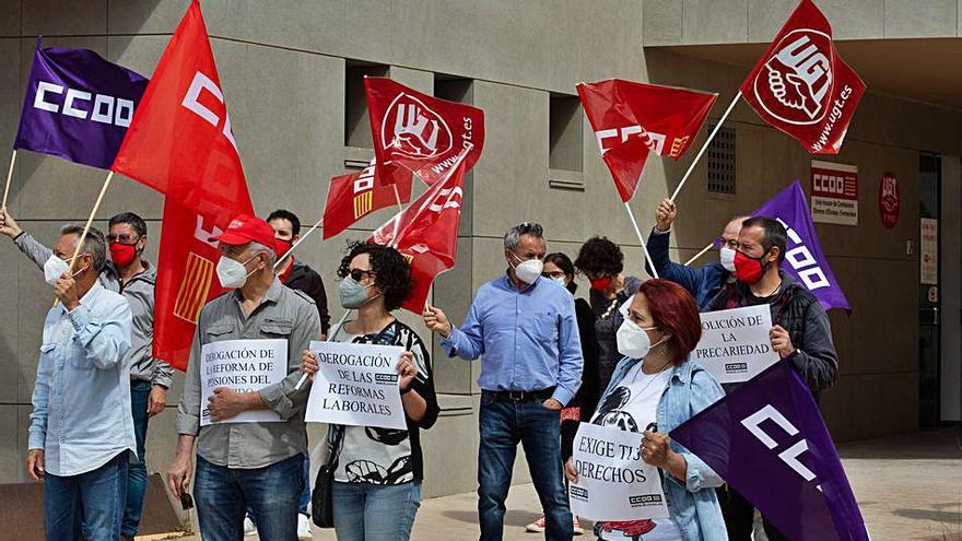 Banderas rojas y moradas y pancartas de reivindicación de los derechos laborales en el Día del Trabajo. 