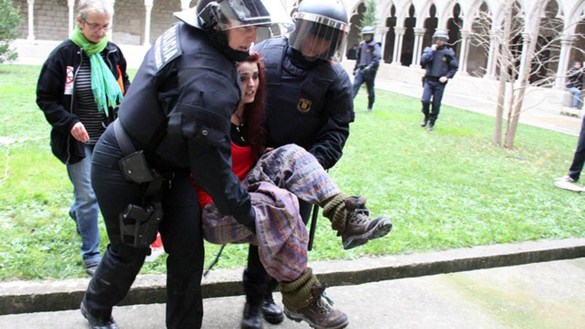 Dos agentes desalojan a una manifestante en la Universitat de Girona.