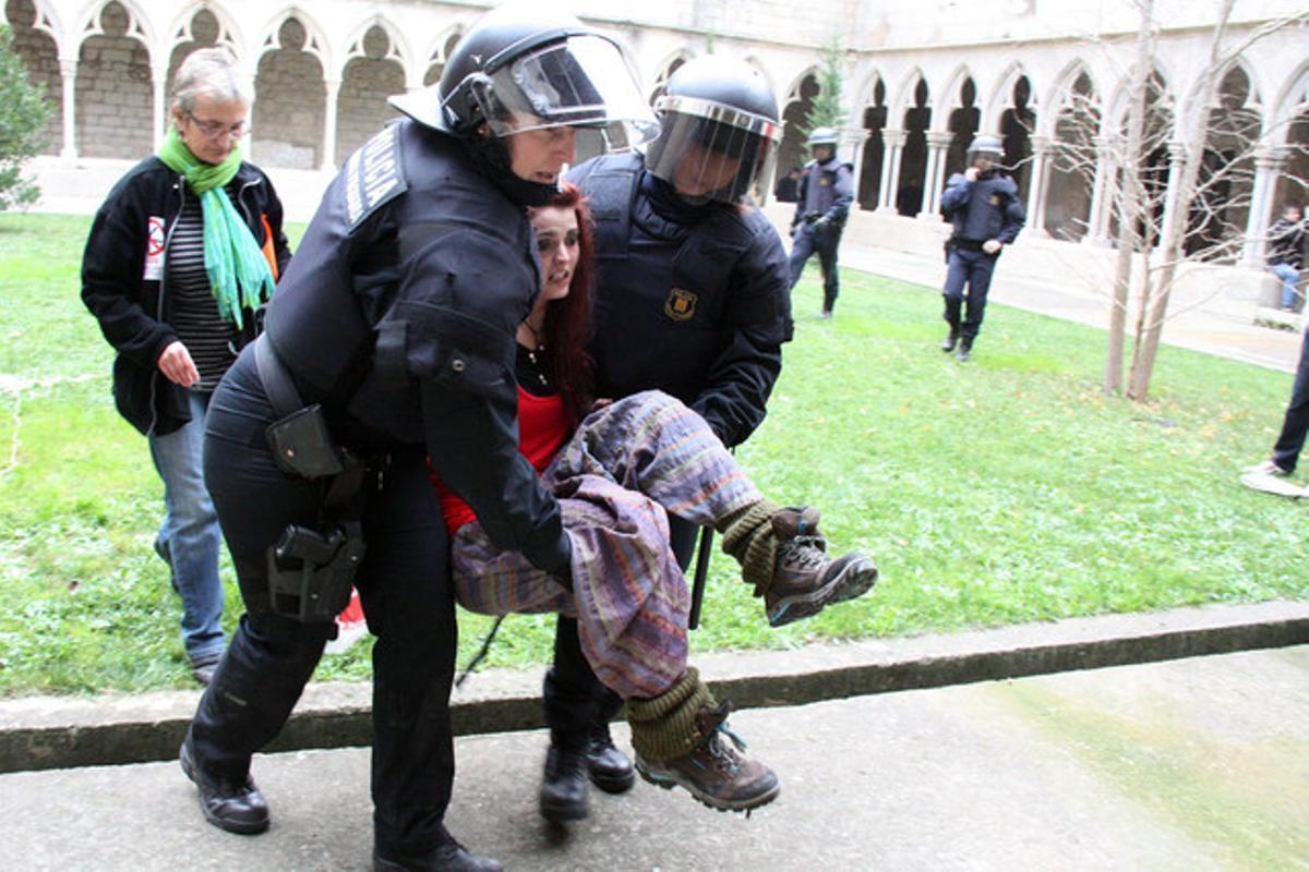 Dos agents desallotgen una manifestant a la Universitat de Girona.