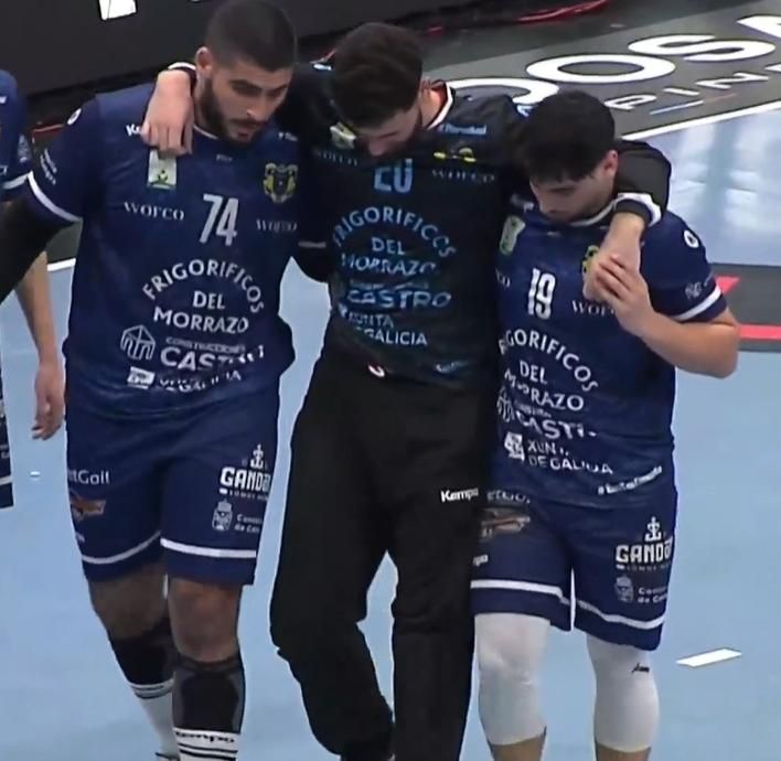 El portero del Frigoríficos, Jorge Pérez, cabizbajo, se retira el domingo de la pista apoyado en Omar Sherif y Arnau Fernández tras lesionarse en la rodilla. |