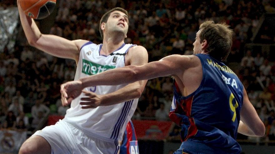 El pívot del Real Madrid, Felipe Reyes , intenta encestar ante la presión del pívot italiano del Barcelona, Denis Marconato,durante el pasado partido de la Liga ACB.