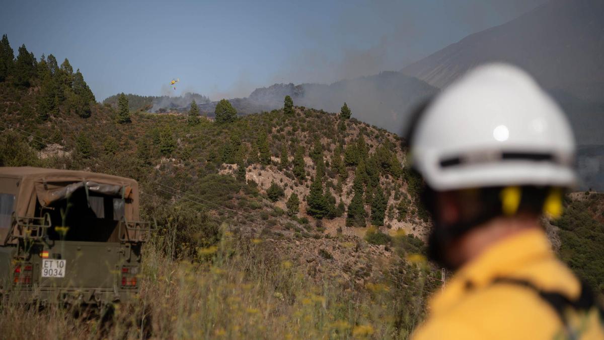 Un efectivo del Brifor observa a un helicóptero sobre la zona afectada por un incendio forestal en Tenerife.