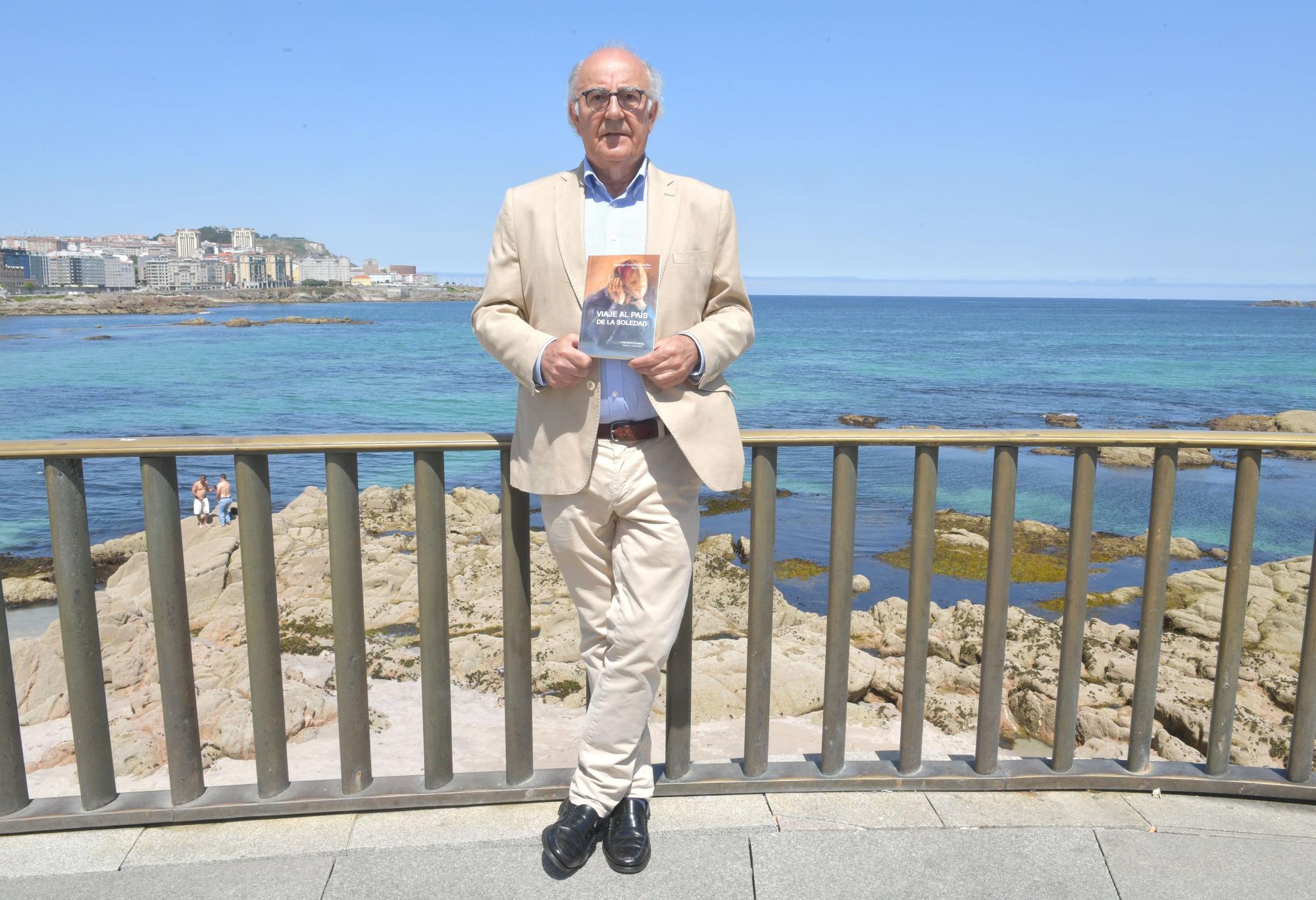 Domingo González, en la Coraza del Orzán, con su libro 'Viaje al país de la soledad'.