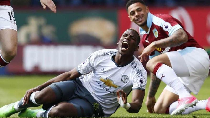 El francés Paul Pogba se duele en el suelo de la entrada que le obligó a abandonar el terreno de juego. // Reuters