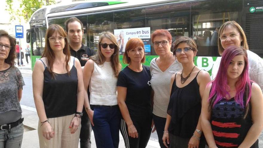 Un grup de botiguers davant la parada del bus urbà del primer tram del carrer de Guimerà.