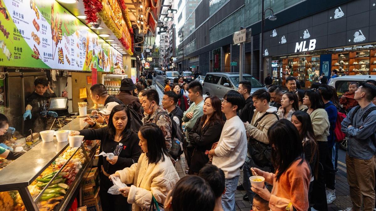 Colas para un puesto de comida callejera, en Hong Kong