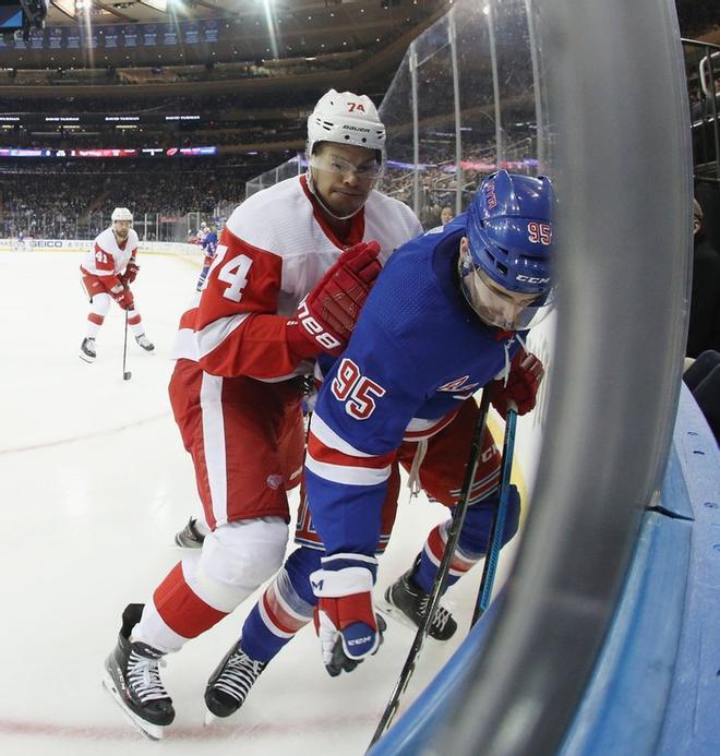 Vinni Lettieri # 95 de los New York Rangers es empujado  por Madison Bowey # 74 de los Detroit Red Wings durante el segundo período en el Madison Square Garden.