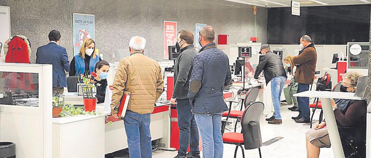 Clientes son atendidos en una oficina bancaria.