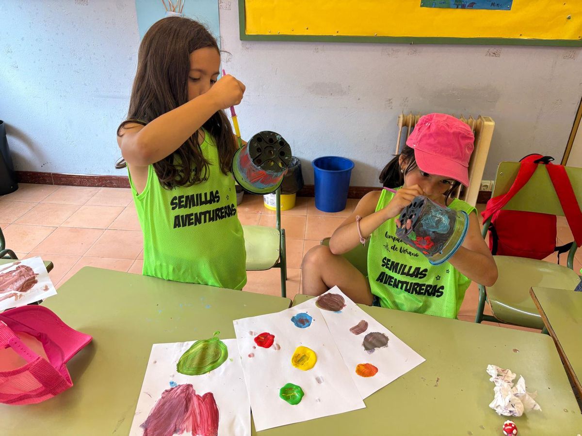 Manuela García y Carmen Vázquez pintan sus macetas.