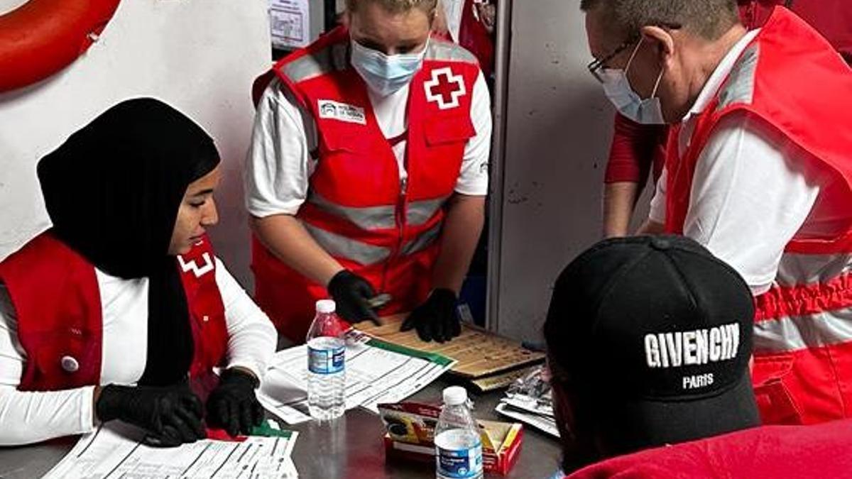 Miembros de Cruz Roja atienden a una mujer llegada en patera a las costas de la Región.