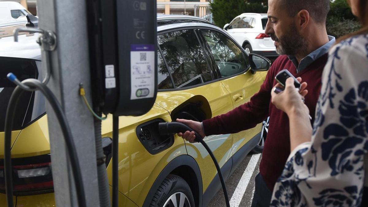 Ángel García, enchufando un coche eléctrico municipal.