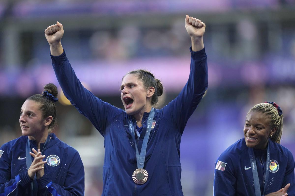 United States' Ilona Maher, centre reacts as she stands on the podium with her bronze medal during the presentation ceremony Rugby Sevens at the 2024 Summer Olympics, in the Stade de France, in Saint-Denis, France, Tuesday, July 30, 2024. (AP Photo/Tsvangirayi Mukwazhi) / EDITORIAL USE ONLY/ONLY ITALY AND SPAIN