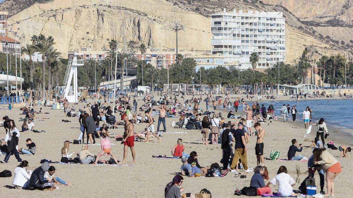 Centenares de personas en la playa del Postiguet de Alicante el día de Navidad.