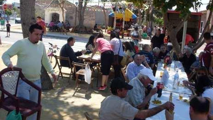 Los vecinos disfrutan de una comida en la Plaza de la Cruz.