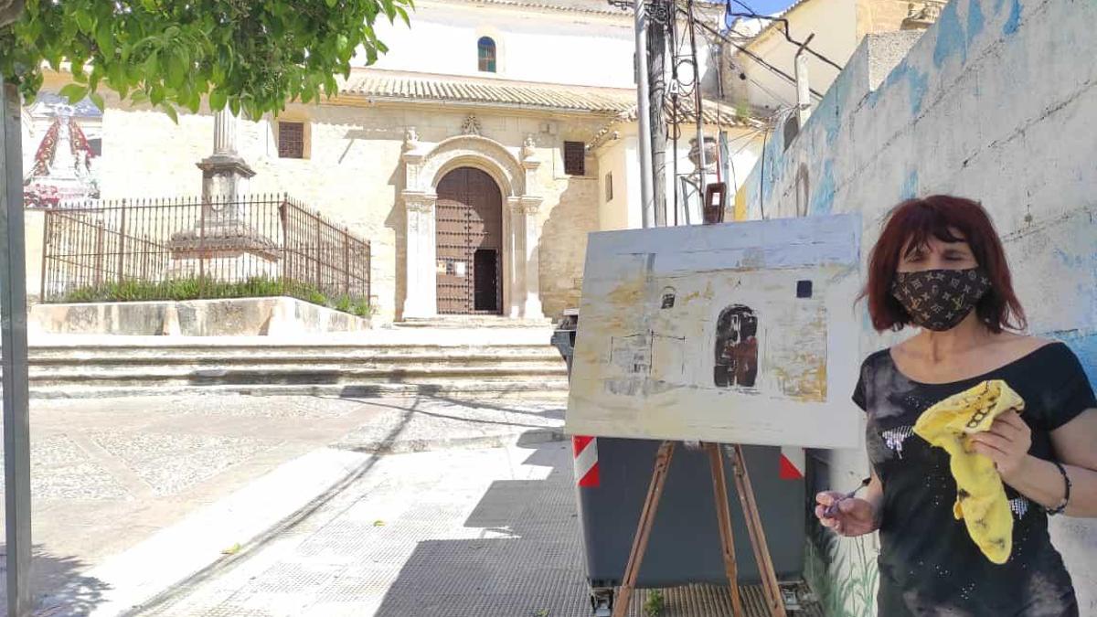 Una artista participante, con su obra, en el primer Certamen de pintura rápida Ciudad de Aguilar.