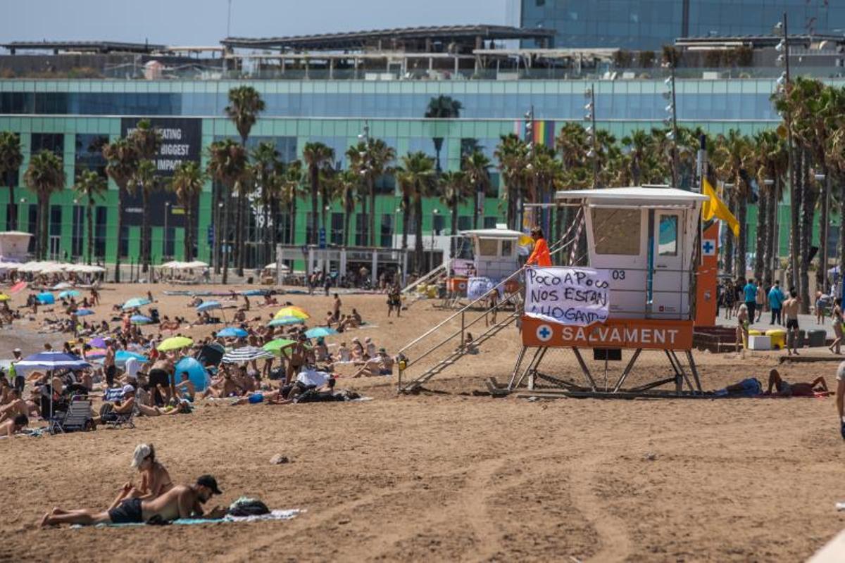La huelga de los socorristas en las playas con pancartas y bandera amarilla