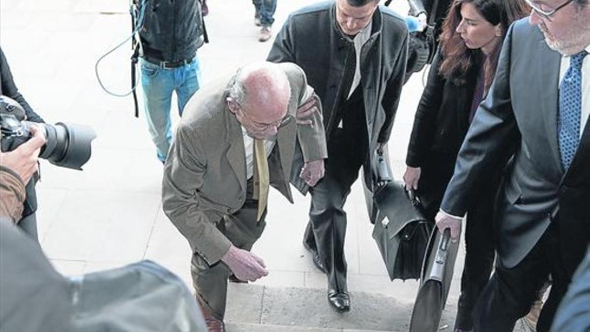 Fèlix Millet, el pasado 24 de febrero, es sujetado por uno de sus abogados tras tropezar con un escalón a la entrada del Palau de Justícia.