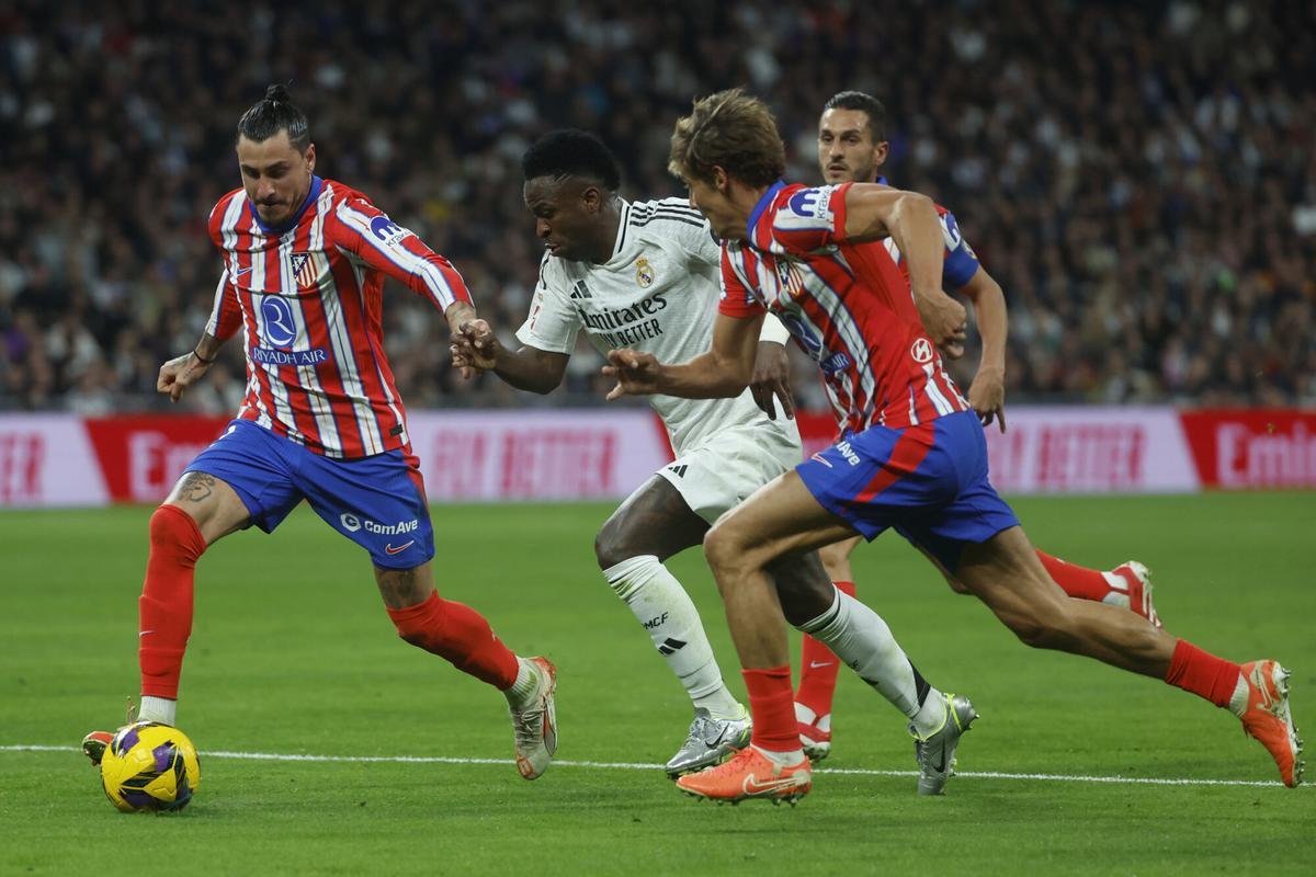 José María Giménez y Vinicius Junior disputan el balón en el Real Madrid - Atlético del Santiago Bernabéu en LaLiga 2024/25