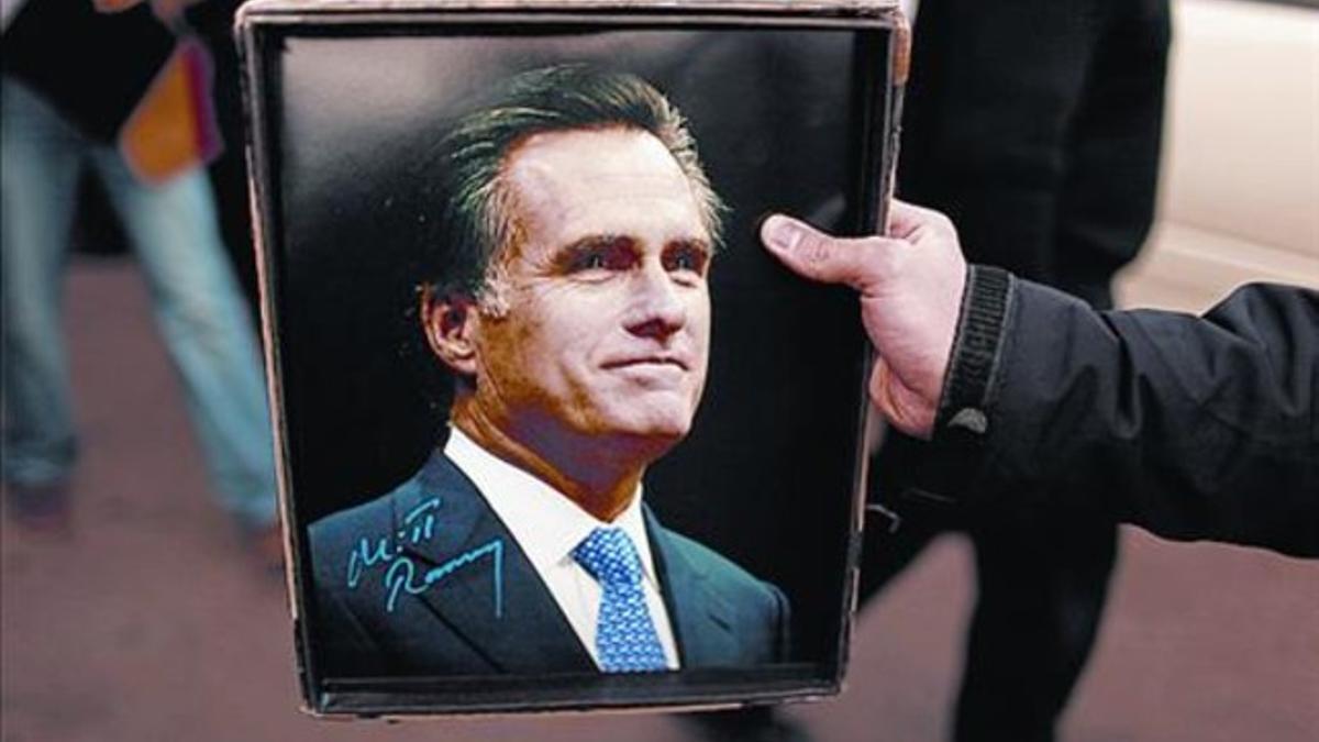 Un seguidor de Romney muestra su fotografía firmada, ayer.