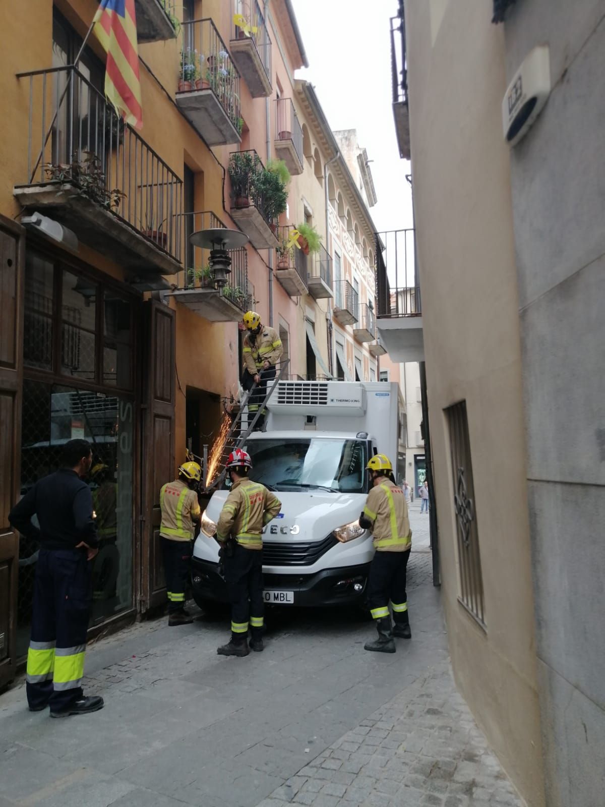 Un camió queda encallat en un carrer de Girona i causa destrosses en un balcó