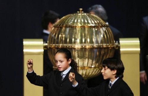 Schoolchildren Ismael and Sherley call out the winning number during the draw for Spain's Christmas Lottery "El Gordo" in Madrid
