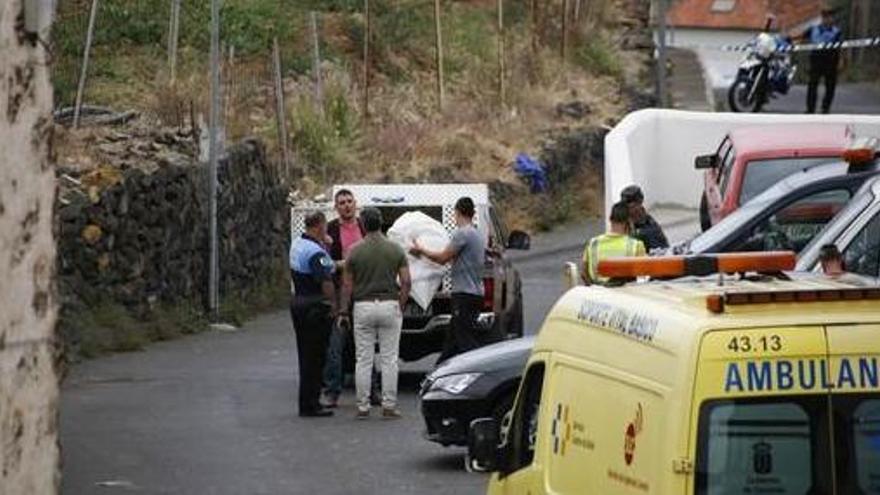 Los agentes sacan uno de los cuerpos de la vivienda.